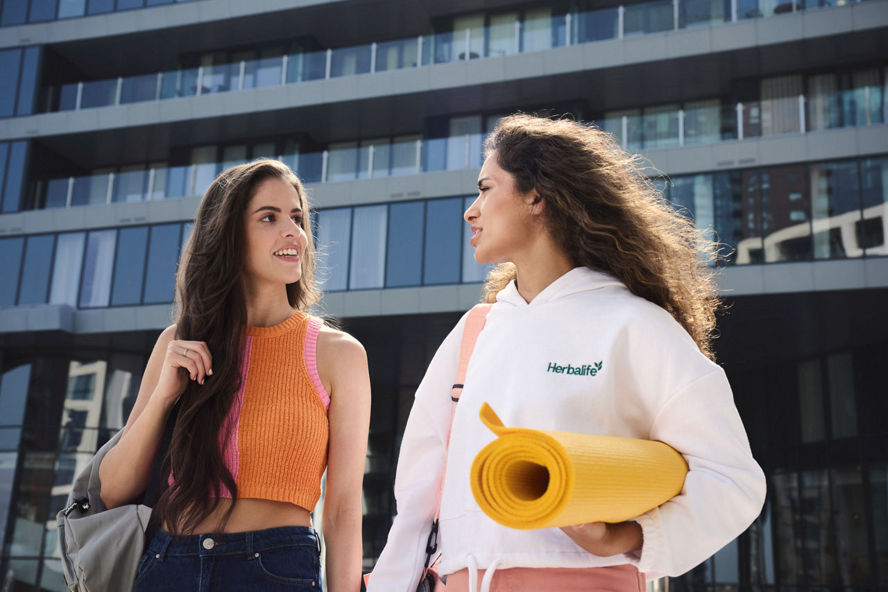 Приятели разговарят, докато се разхождат на открито.